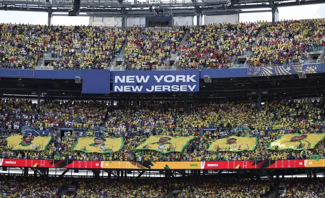 Fans hold banners of legendary Brazilian players before the World Cup Group C soccer match between Brazil and Morocco in East Rutherford, N.J., near New York, Saturday, June 13, 2026. (AP Photo/Adam Hunger)