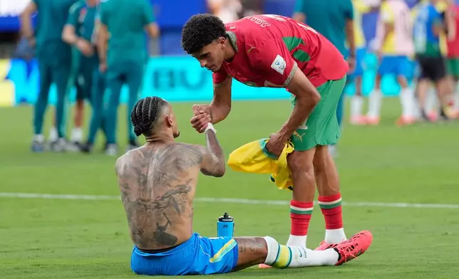 Brazil's Raphinha (11) and Morocco's Ayoub Amaimouni (21) trade jerseys during the World Cup Group C soccer match between Brazil and Morocco in East Rutherford, N.J., near New York, Saturday, June 13, 2026. (AP Photo/Yuki Iwanmura)