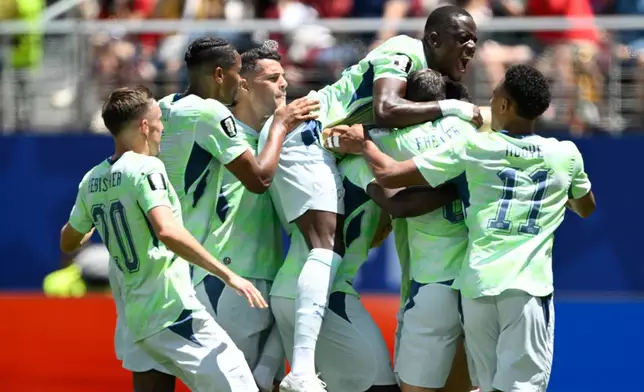 Switzerland's Breel Embolo is mobbed by teammates after scoring the opening goal from the penalty spot during the World Cup Group B soccer match between Qatar and Switzerland in Santa Clara, Calif., near San Francisco, Saturday, June 13, 2026. (AP Photo/Eakin Howard)