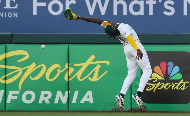Athletics right fielder Lawrence Butler over runs the ball and can't make the catch during the fifth inning of a baseball game against the Pittsburgh Pirates Wednesday, June 17, 2026, in West Sacramento, Calif. (AP Photo/Scott Marshall)