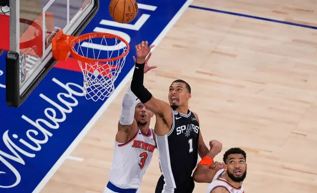 San Antonio Spurs forward Victor Wembanyama (1) shoots as New York Knicks guard Josh Hart (3) and center Karl-Anthony Towns (32) defend during the second half of Game 3 of the NBA Finals basketball series, Monday, June 8, 2026, in New York. (AP Photo/Yuki Iwamura)