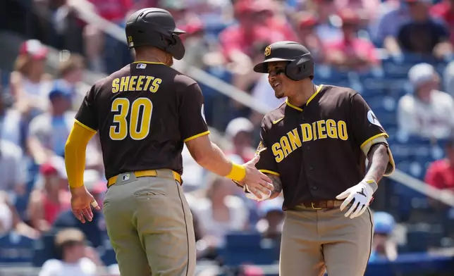 San Diego Padres' Manny MacHado, right, celebrates his two-run home run with teammate Gavin Sheets, during the seventh inning of a baseball game against the Philadelphia Phillies, Thursday, June 4, 2026, in Philadelphia. (AP Photo/Matt Rourke)