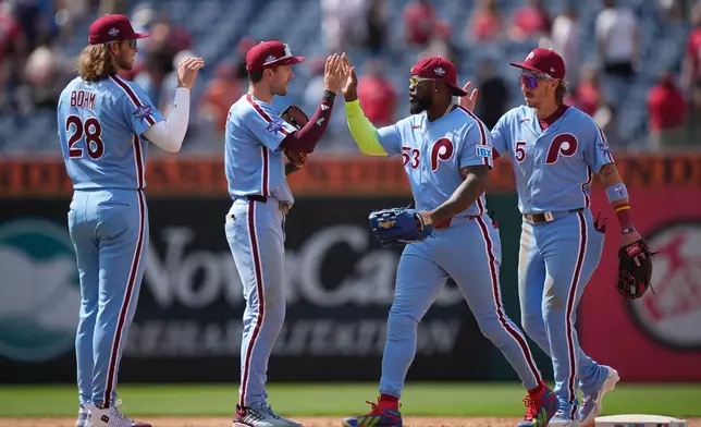 Philadelphia Phillies' players, from left, Alec Bohm, Trea Turner, Adolis García, and Bryson Stott celebrate after winning a baseball game against the San Diego Padres, Thursday, June 4, 2026, in Philadelphia. (AP Photo/Matt Rourke)