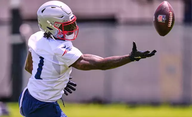 New England Patriots wide receiver A.J. Brown reaches for a pass during an NFL football practice, Tuesday, June 2, 2026, in Foxborough, Mass. (AP Photo/Charles Krupa)