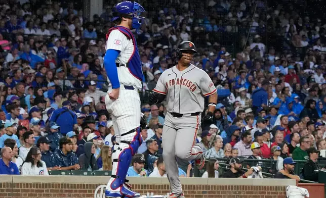 San Francisco Giants' Rafael Devers, right, scores on a one-run single by Jung Hoo Lee, of South Korea, as Chicago Cubs catcher Carson Kelly looks to the field during the first inning of a baseball game in Chicago, Sunday, June 7, 2026. (AP Photo/Nam Y. Huh)