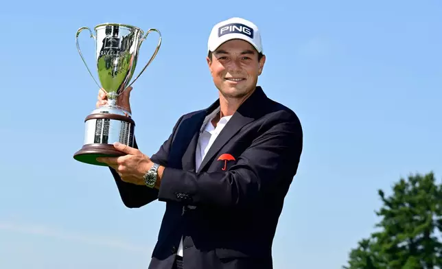 Viktor Hovland, of Norway, holds the Travelers Championship golf tournament trophy at TPC River Highlands, Monday, June 29, 2026, in Cromwell, Conn. (AP Photo/Jessica Hill)