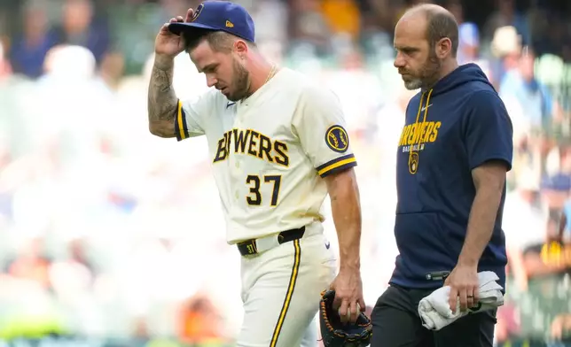Milwaukee Brewers pitcher DL Hall (37) walks off the mound with Milwaukee Brewers' Head Athletic Trainer Brad Epstein during the fifth inning of a baseball game against the San Francisco Giants Thursday, June 4, 2026, in Milwaukee. (AP Photo/Kayla Wolf)