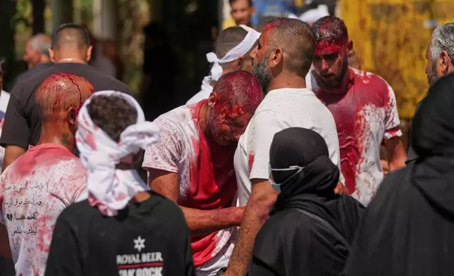EDS NOTE: GRAPHIC CONTENT - A Lebanese Shiite weeps for a friend killed during the war as he bleeds from a self-inflicted ceremonial head wound during Ashoura, when Shiites commemorate the martyrdom of Imam Hussein, the grandson of the Prophet Muhammad, in Nabatiyeh, southern Lebanon, Friday, June 26, 2026. (AP Photo/Hassan Ammar)