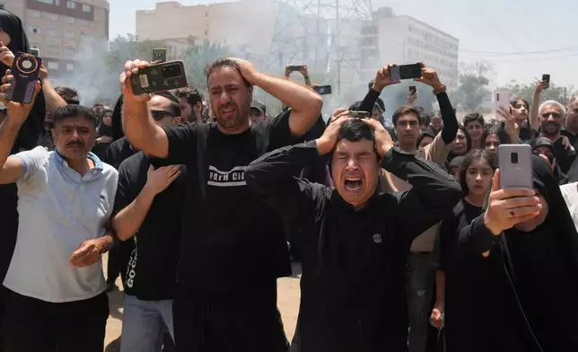 People mourn as they film the re-enactment of the battle of Karbala in A.D. 680 in present-day Iraq, in which Imam Hussein, a grandson of the Prophet Muhammad, one of Shiite Islam's most beloved saints, and his family and companions were killed after refusing to pledge allegiance to the Umayyad caliphate, in Tehran, Iran, Thursday, June 25, 2026, in the holy day of Ashoura which commemorates their martyrdom. (AP Photo/Vahid Salemi)