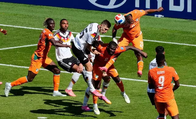 Germany's Nico Schlotterbeck (15) vies for a high ball with Ivory Coast's Emmanuel Agbadou (20) and Franck Kessie (8) during the World Cup Group E soccer match between Germany and Ivory Coast in Toronto, Saturday, June 20, 2026. (Chris Young/The Canadian Press via AP)