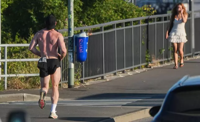 A man runs over a bridge in Frankfurt, Germany, Wednesday, June 24, 2026. (AP Photo/Michael Probst)