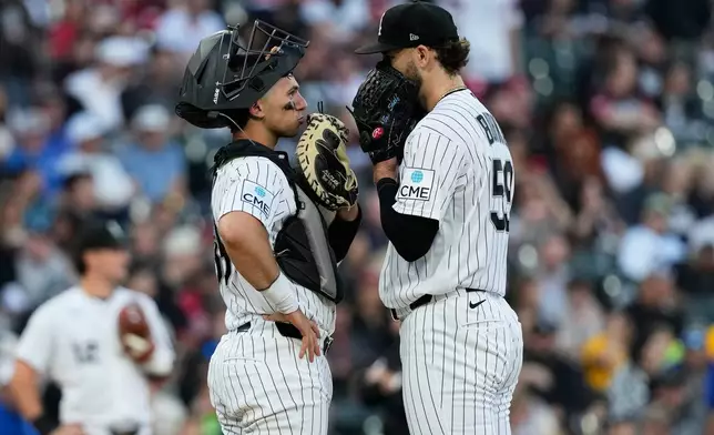 Chicago White Sox catcher Drew Romo, left, talks with starting pitcher Sean Burke during the fifth inning of a baseball game against the Cleveland Guardians in Chicago, Tuesday, June 23, 2026. (AP Photo/Nam Y. Huh)
