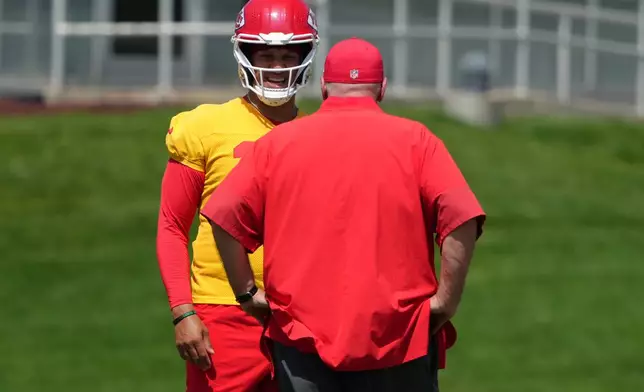Kansas City Chiefs quarterback Patrick Mahomes, back, talks with head coach Andy Reid during an NFL football team's practice Wednesday, June 10, 2026, in Kansas City, Mo. (AP Photo/Ed Zurga)