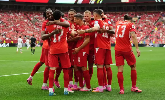 Switzerland's Ruben Vargas (17) is mobbed by teammates after scoring their first goal during the World Cup Group B soccer match between Switzerland and Canada in Vancouver, British Columbia, Wednesday, June 24, 2026. (Ethan Cairns/The Canadian Press via AP)
