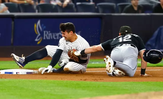 New York Yankees' shortstop Anthony Volpe is tagged out at third base by Chicago White Sox's Colson Montgomery (12) during the seventh inning of a baseball game, Thursday, June 18, 2026, in New York. (AP Photo/Noah K. Murray)