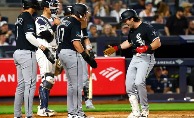 Chicago White Sox designated hitter Andrew Benintendi, right, celebrates with Jacob Gonzalez after hitting a grand slam against the New York Yankees during the eighth inning of a baseball game, Thursday, June 18, 2026, in New York. (AP Photo/Noah K. Murray)