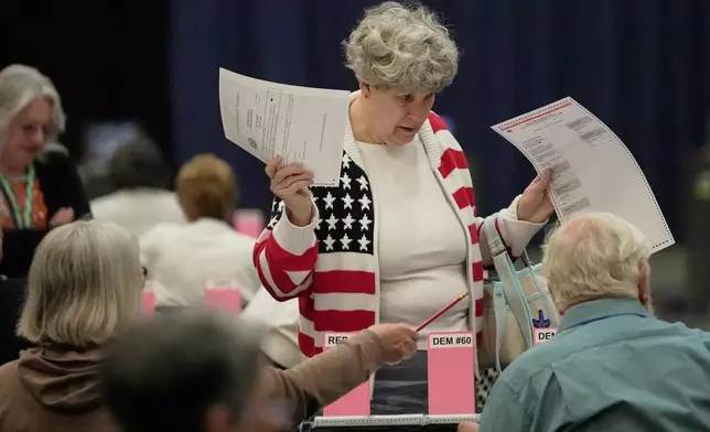 Mary Saunders gets help from election officials after picking up her ballots to vote in the Maine Primary, Tuesday, June 9, 2026, in Augusta, Maine. (AP Photo/Robert F. Bukaty)