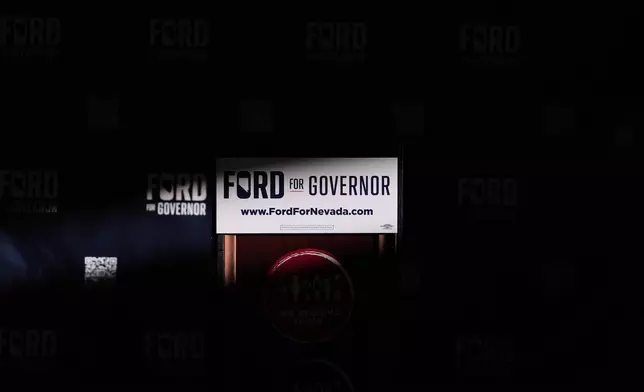 Light illuminates the podium for Gubernatorial candidate Aaron Ford, attorney general of Nevada, during a primary election night watch party Tuesday, June 9, 2026, in Las Vegas. (AP Photo/Jae C. Hong)