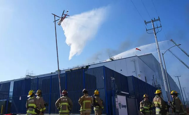Water is dropped by helicopter at a warehouse fire in the Boyle Heights section of Los Angeles on Wednesday, June 17, 2026. (AP Photo/Jae C. Hong)