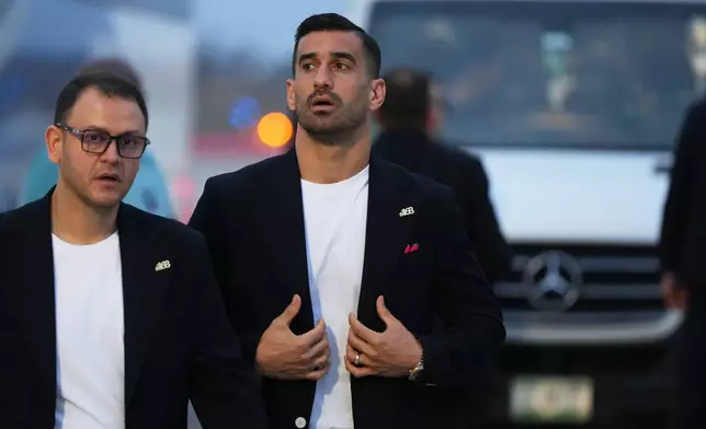 Iran's Ehsan Hajisafi, center, walks with a team official as he arrives with his teammates for the World Cup soccer tournament in Tijuana, Mexico, Sunday, June 7, 2026. (AP Photo/Gregory Bull)