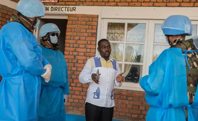 Richard Lokudu, center, the medical director of Mongbwalu General Hospital, speaks with UN peacekeepers in Mongbwalu, Congo, Friday, June 5, 2026. (AP Photo/Moses Sawasawa)