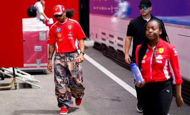 Ferrari driver Lewis Hamilton of Britain, front left, walks at the Barcelona Catalunya racetrack in Montmelo, near Barcelona, Spain, Thursday, June 11, 2026. (AP Photo/ Joan Monfort)