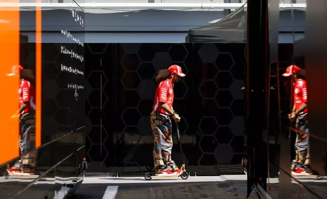 Ferrari driver Lewis Hamilton of Britain rides a scooter at the Barcelona Catalunya racetrack in Montmelo, near Barcelona, Spain, Thursday, June 11, 2026. (AP Photo/ Joan Monfort)