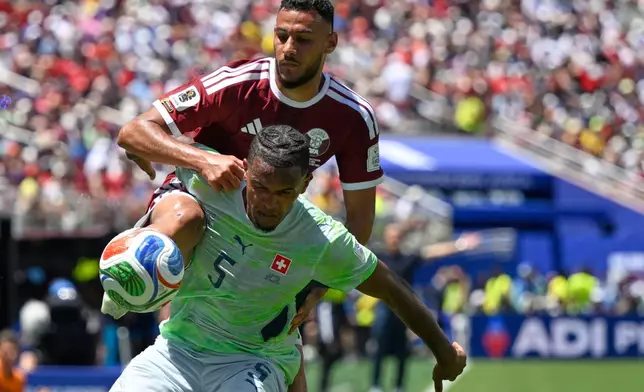 Qatar's Mohamed Manai attempts to get the ball as Switzerland's Manuel Akanji defends during the World Cup Group B soccer match between Qatar and Switzerland in Santa Clara, Calif., near San Francisco, Saturday, June 13, 2026. (AP Photo/Eakin Howard)