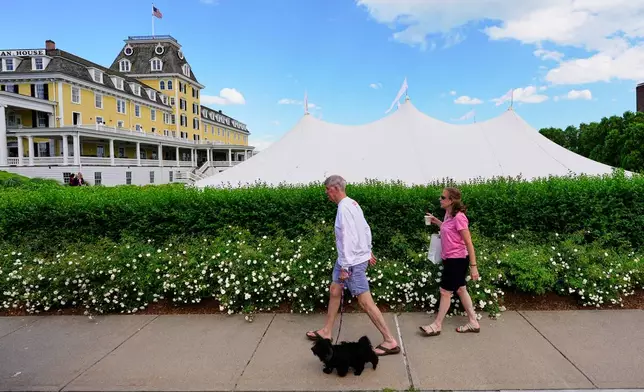 A couple walks by the Ocean House hotel where a temporary event tent prompted speculation of the possibility of Taylor Swift's impending wedding, Saturday, June 20, 2026, in Westerly, R.I. (AP Photo/Robert F. Bukaty)