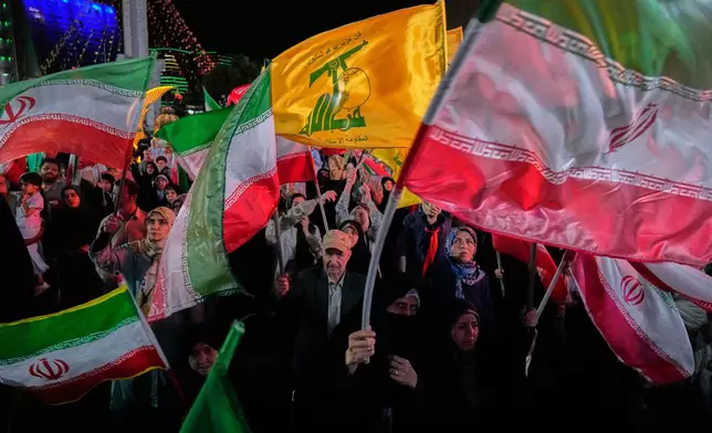 Pro-government Iranian demonstrators wave their country's flags and Lebanon's militant Hezbollah group flags in a gathering in Tehran, Iran, Sunday, June 7, 2026. (AP Photo/Vahid Salemi)