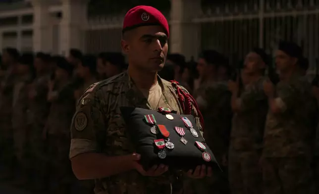 A Lebanese Army soldier carries the medals of Lebanese Brig. Gen. Wissam Sabra during his funeral procession in Beirut, Lebanon, Sunday, June 7, 2026, a day after Sabra was killed in an Israeli airstrike in south Lebanon along with a captain and another soldier, according to the Lebanese Army. (AP Photo/Hassan Ammar)