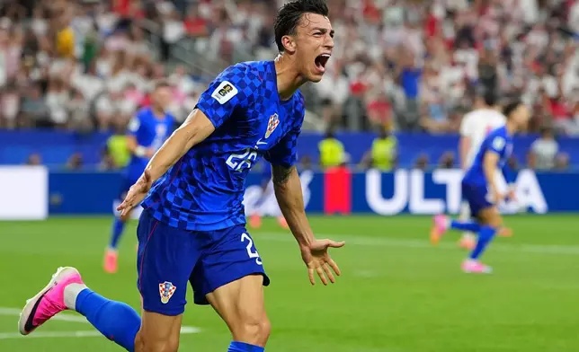 Croatia's Petar Musa celebrates scoring his side's 2nd goal during the World Cup Group L soccer match between England and Croatia in Arlington, Texas, near Dallas, Wednesday, June 17, 2026. (AP Photo/Julio Cortez)