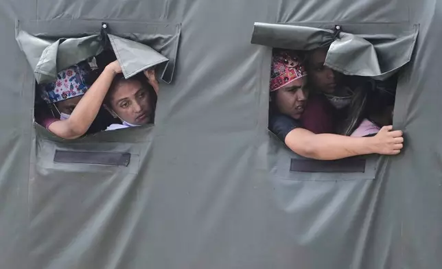 Health workers ride in a truck on their way to join earthquake relief efforts in La Guaira, Venezuela, Sunday, June 28, 2026. (AP Photo/Fernando Vergara)