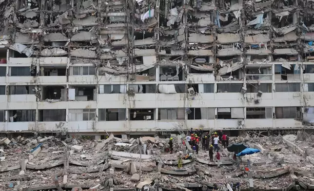 Rescue workers search through the rubble of a building that collapsed when earthquakes struck La Guaira, Venezuela, Sunday, June 28, 2026. (AP Photo/Matias Delacroix)