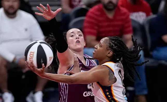 Indiana Fever guard Kelsey Mitchell, right, shoots around Toronto Tempo guard Marina Mabrey, center, in the first half of a WNBA Commissioner's Cup basketball game in Indianapolis, Tuesday, June 16, 2026. (AP Photo/Michael Conroy)