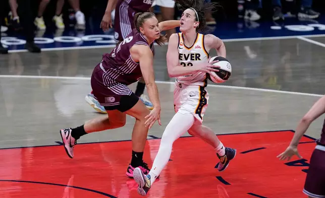Indiana Fever guard Caitlin Clark, right, drives on Toronto Tempo forward Laura Juskaite in the first half of a WNBA Commissioner's Cup basketball game in Indianapolis, Tuesday, June 16, 2026. (AP Photo/Michael Conroy)