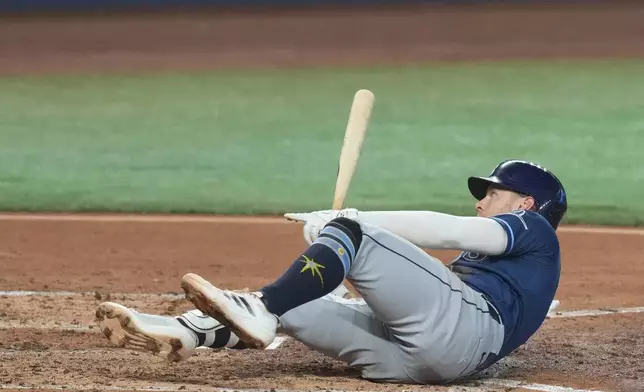 Tampa Bay Rays Taylor Walls signals to the home plate umpire after he was hit by a pitch during the fifth inning of a baseball game against the Miami Marlins Sunday, June 7, 2026, in Miami. (AP Photo/Marta Lavandier)