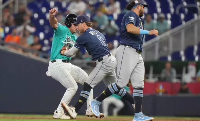 Tampa Bay Rays shortstop Taylor Walls (6) tags Miami Marlins' Jakob Marsee as he is caught between first and second base during the second inning of a baseball game Sunday, June 7, 2026, in Miami. (AP Photo/Marta Lavandier)