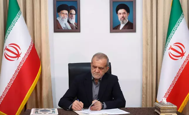 In this photo realised by Iran Presidentcy Office, Iranian President Masoud Pezeshkian signs a memorandum of understanding already signed by U.S. President Donald Trump aimed at ending the war and launching negotiations on a broader agreement, in Tehran, Iran, early Thursday, June 18, 2026. (Iranian Presidency Office via AP)
