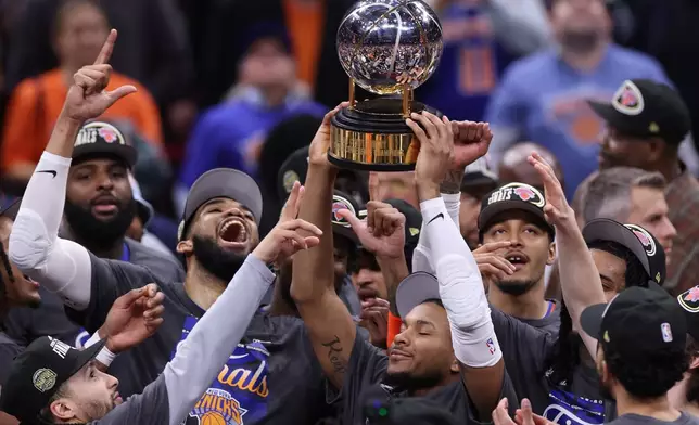 The New York Knicks hold the Eastern Conference Championship trophy after Game 4 in the Eastern Conference finals NBA basketball playoffs series against the Cleveland Cavaliers in Cleveland, Monday, May 25, 2026. (AP Photo/Tim Phillis)