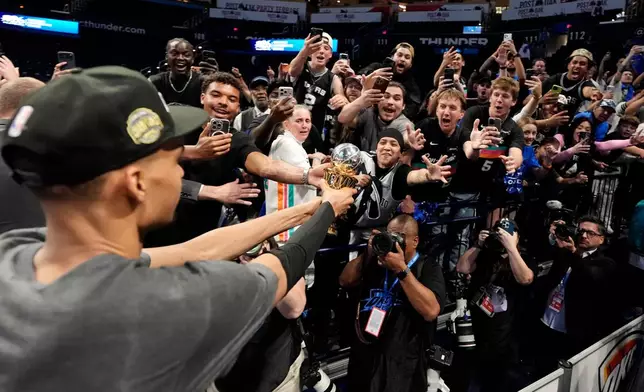San Antonio Spurs forward Victor Wembanyama walks over to Spurs fans as he holds his MVP trophy as he celebrates after Game 7 of the Western Conference finals of the NBA basketball playoffs series win against the Oklahoma City Thunder, Saturday, May 30, 2026, in Oklahoma City. (AP Photo/Tony Gutierrez)