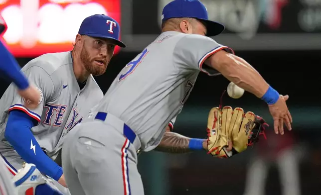 Texas Rangers right fielder Brandon Nimmo watch as second baseman Cody Freeman, right, catches a pop up by St. Louis Cardinals' Masyn Winn for an out during the sixth inning of a baseball game Wednesday, June 3, 2026, in St. Louis. (AP Photo/Jeff Roberson)