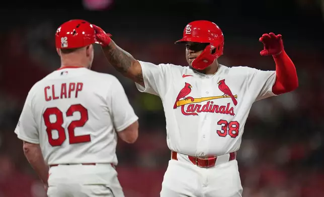 St. Louis Cardinals' Nelson Velázquez (38) celebrates after hitting an RBI single as first base coach Stubby Clapp (82) watches during the sixth inning of a baseball game against Texas Rangers Wednesday, June 3, 2026, in St. Louis. (AP Photo/Jeff Roberson)