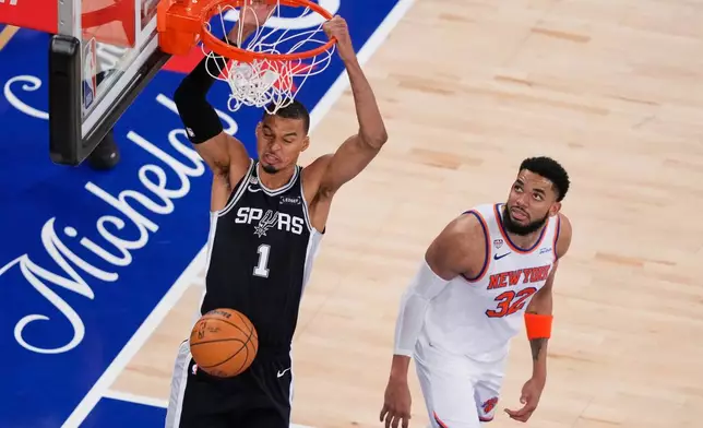 San Antonio Spurs forward Victor Wembanyama (1) dunks as New York Knicks center Karl-Anthony Towns (32) looks on during the second half of Game 3 of the NBA Finals basketball series, Monday, June 8, 2026, in New York. (AP Photo/Yuki Iwamura)