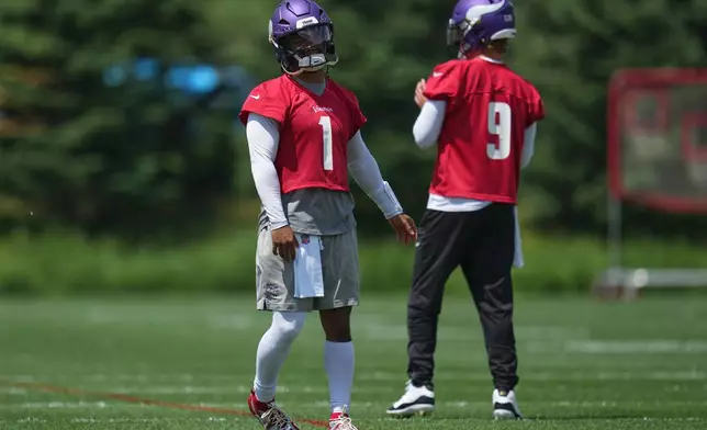 Minnesota Vikings quarterbacks Kyler Murray (1) and J.J. McCarthy (9) stand on the field during an NFL football practice Tuesday, June 9, 2026 in Eagan, Minn. (AP Photo/Abbie Parr)