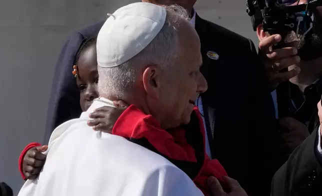 Pope Leo XIV hug a child during a meeting with migrants at the 'Las Raices' center, in San Cristobal de la Laguna, Tenerife, Spain, Friday, June 12, 2026. (AP Photo/Alessandra Tarantino)