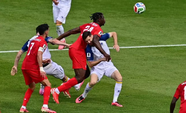 Canada's Promise David (24) grapples with Bosnia Armin Gigovic (8) during the second half of the World Cup Group B soccer match between Canada and Bosnia, Friday, June 12, 2026, in Toronto. (Sammy Kogan/The Canadian Press via AP)