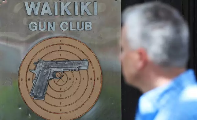 FILE - People walk past the Waikiki Gun Club, Thursday, June, 23, 2022 in Honolulu. (AP Photo/Marco Garcia)