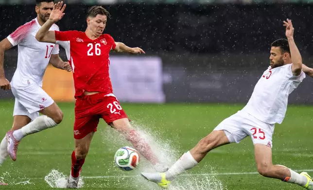Switzerland's Cedric Itten, left, fights for the ball with Jordan's Mohammad Al-Dawoud during the international friendly soccer match between Switzerland and Jordan in St. Gallen, Switzerland, Sunday, May 31, 2026. (Peter Schneider/Keystone via AP)