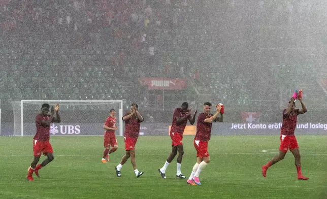 Players under poruing rain during the international friendly soccer match between Switzerland and Jordan in St. Gallen, Switzerland, Sunday, May 31, 2026. (Peter Schneider/Keystone via AP)